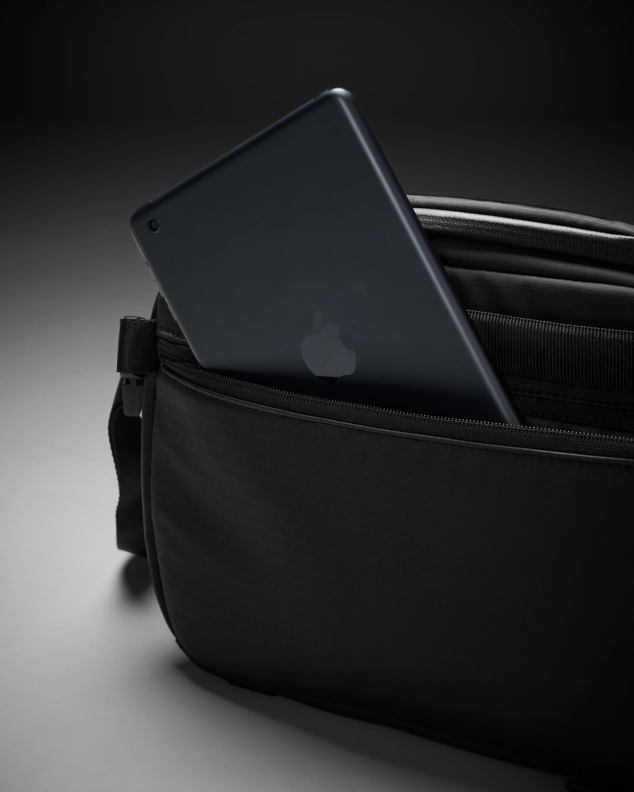 Black laptop in a black bag on a dark background