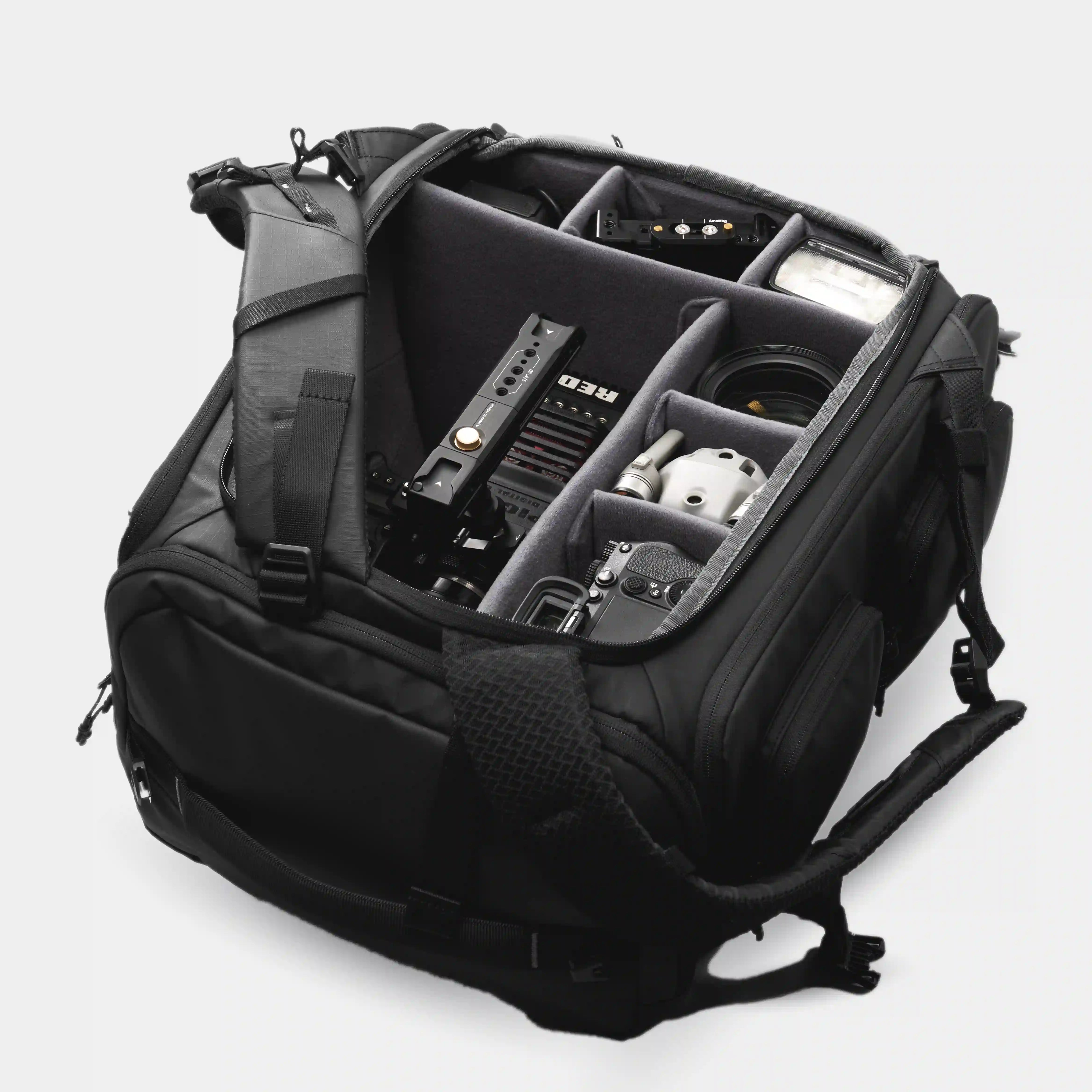 Black backpack with compartments and equipment on a white background