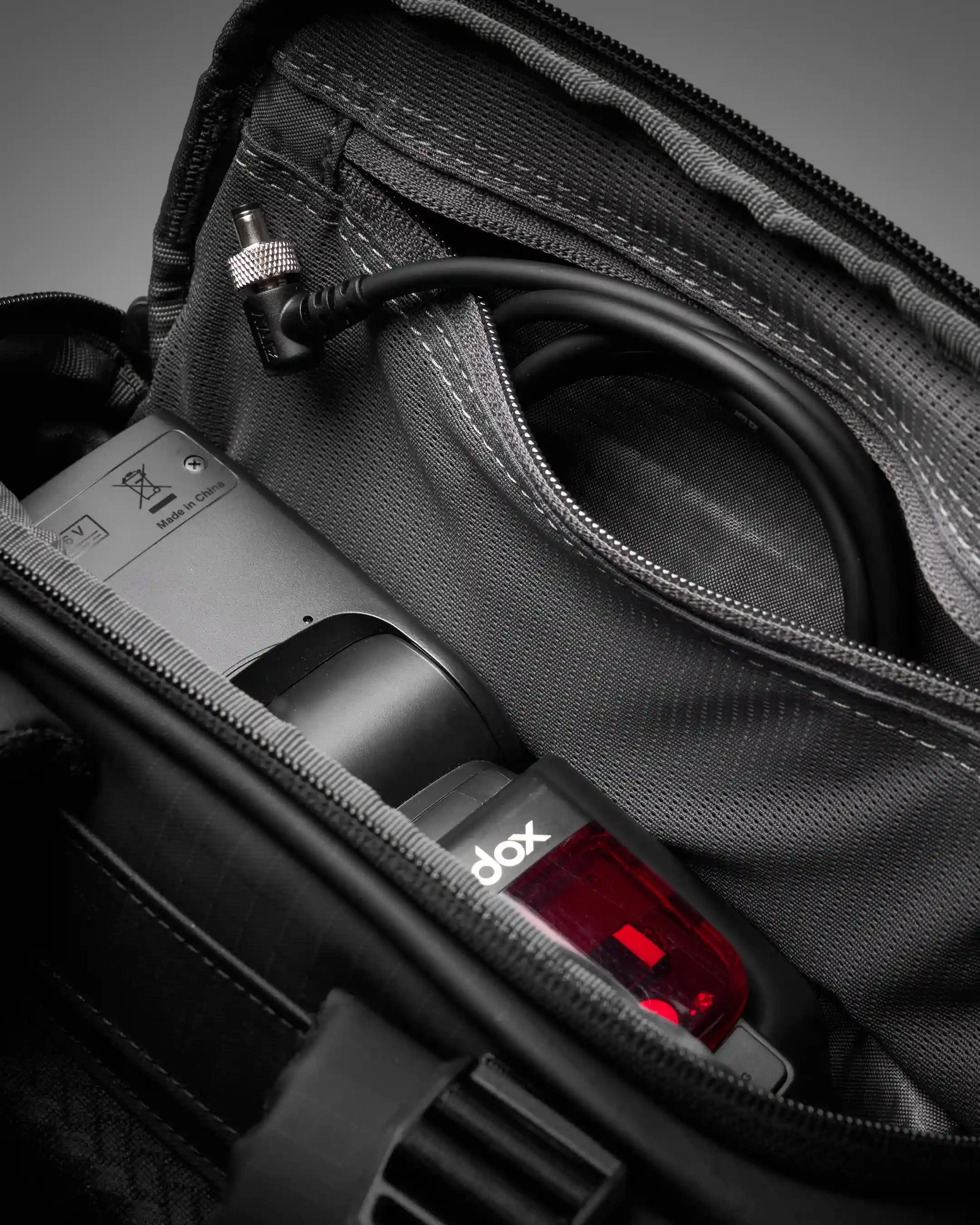 Black travel bag with a power bank labeled 'dox' inside, on a dark background