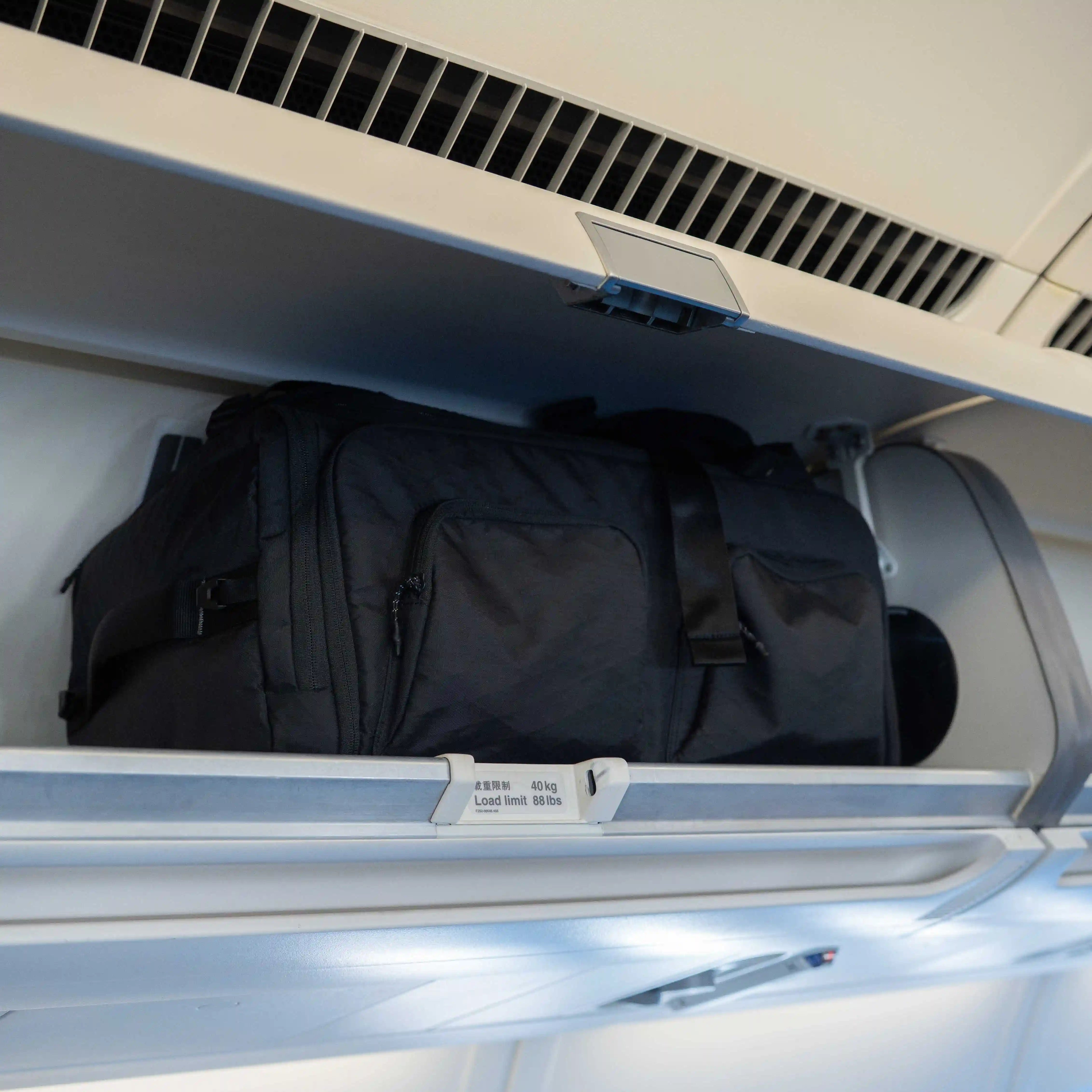 Sakk Pack Cube stored in airplane overhead cabin. Fits cinema cameras, laptop, and travel essentials for professional creators.