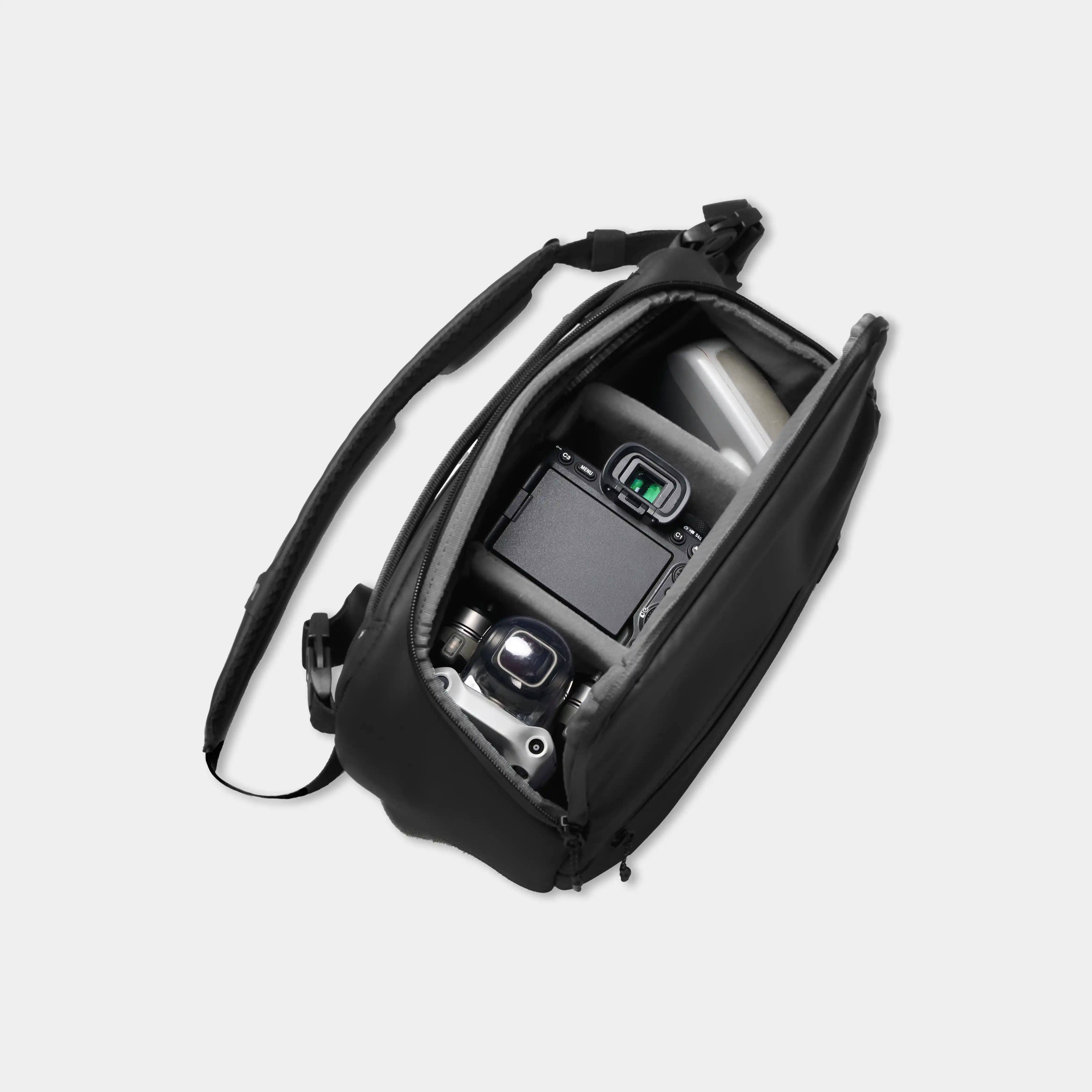 Black camera bag with a camera inside on a light gray background
