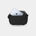 Black crossbody bag with an Apple product inside on a light gray background