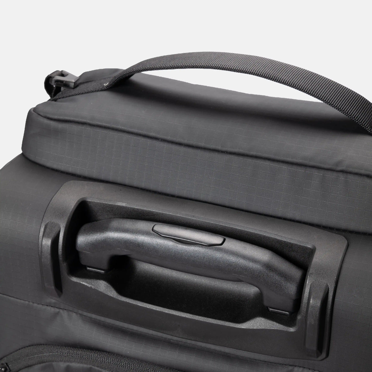 Close-up of a dark gray soft-sided bag with a top handle and a recessed telescoping handle on the front, shown against a light gray background.
