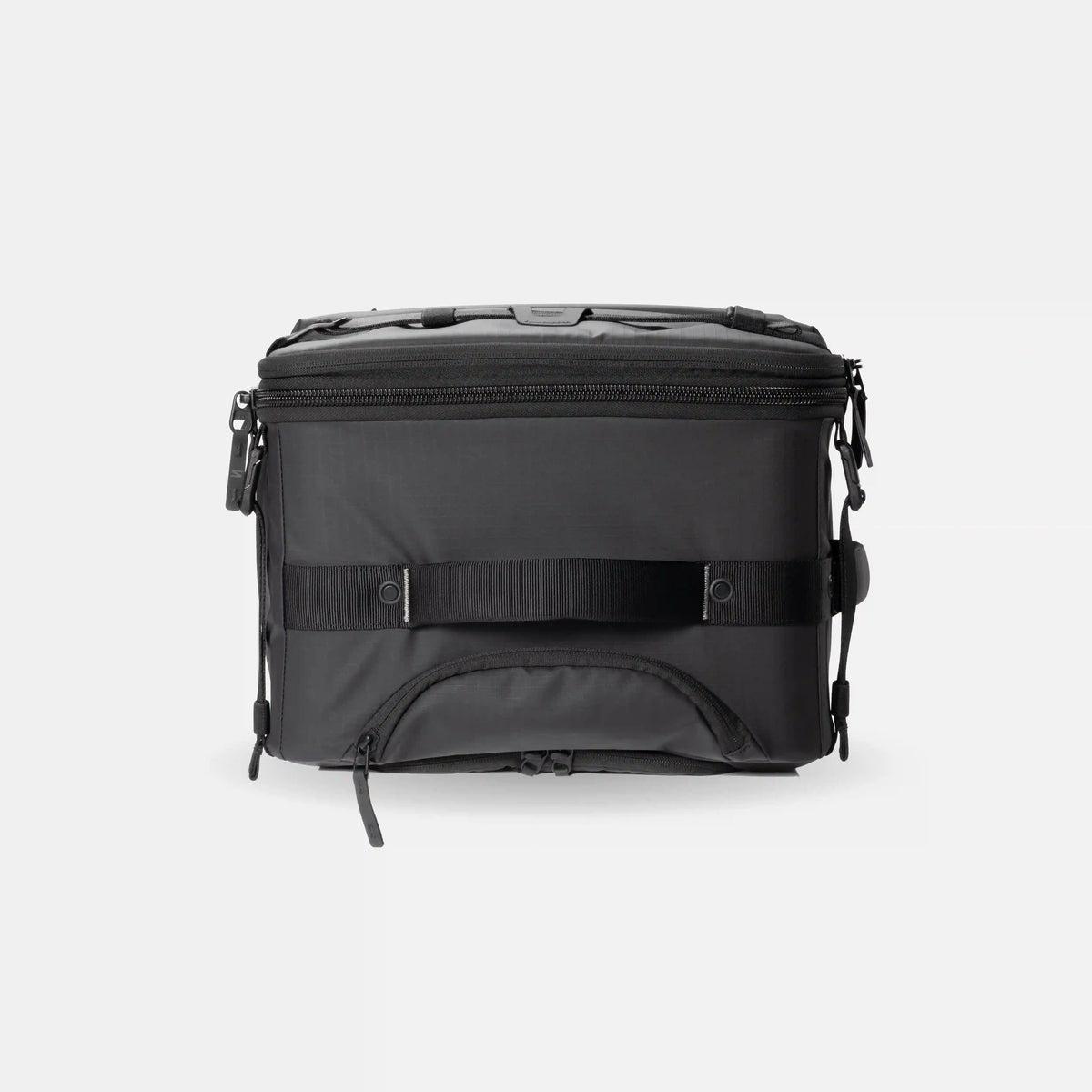 A black soft-sided cooler bag with a front zipper pocket, a horizontal compression strap, and top carry handles, shown against a light gray background.