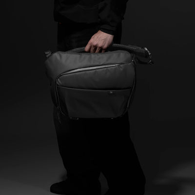 Person holding sling bag with one hand 
