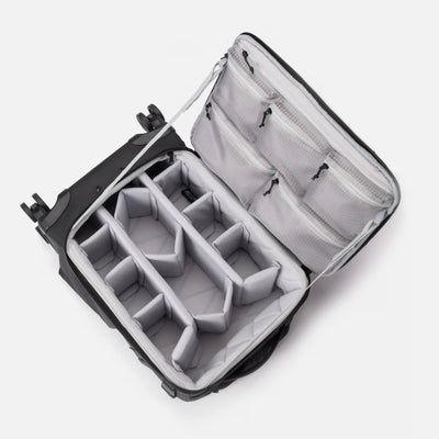 An open hard-shell suitcase or duffel bag with a gray padded interior organizer, shown on a clean white background.