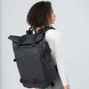 Person wearing a black backpack against a light gray background