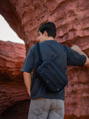 Black crossbody gear bag for creators and tech users. Compact everyday carry with strong zippers.