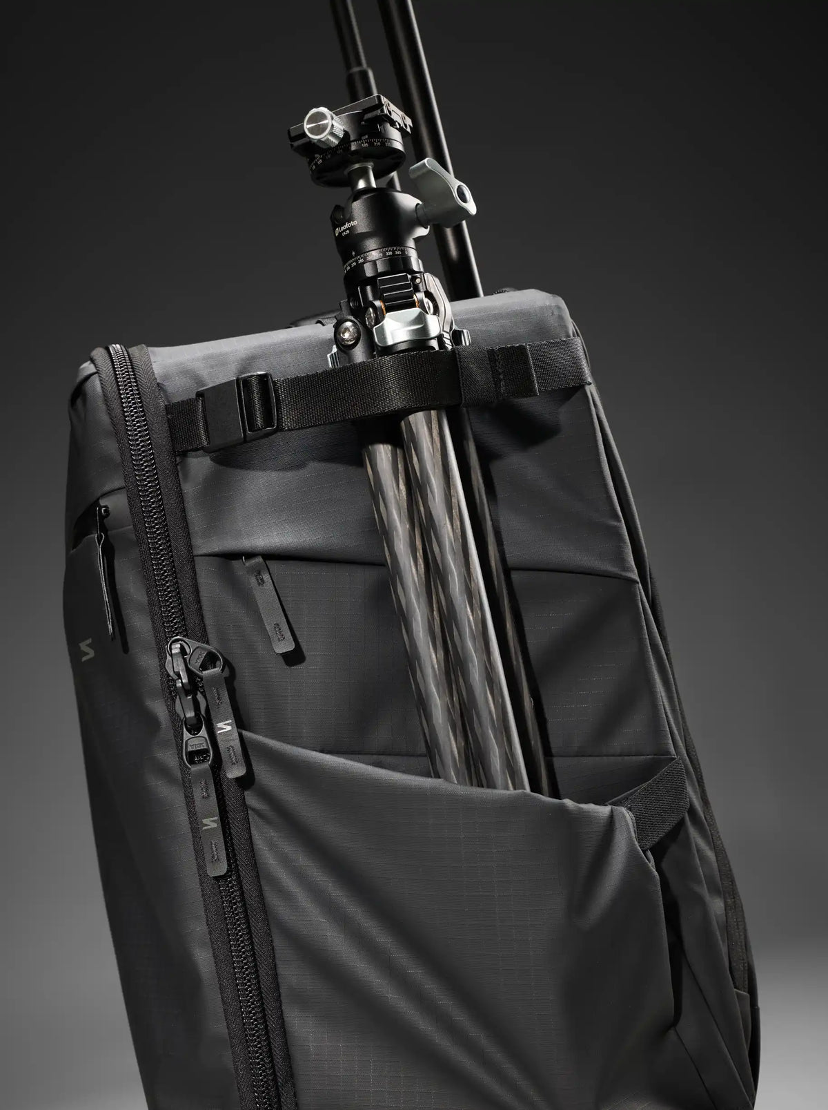 A side of a roller bag with side pocket for carrying a tripod.